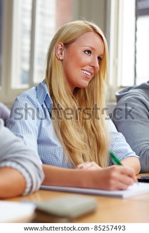 Happy young college student learning in class