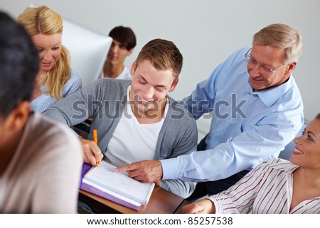 Teacher helping some students in university class