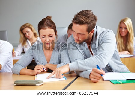 Student helping other student in class in university