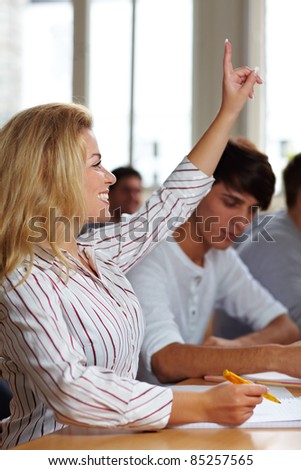 Female student raising her hand in university class