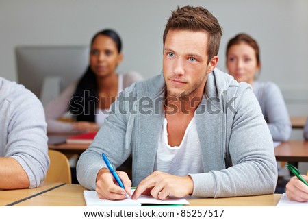 Young student taking notes in university class