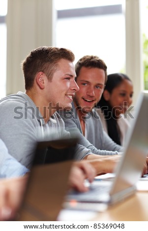 Happy young students smiling in university class