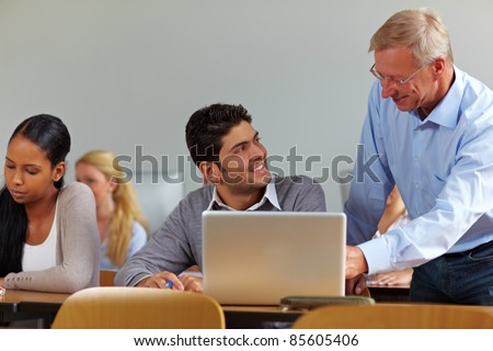 Lecturer talking to student in class at university