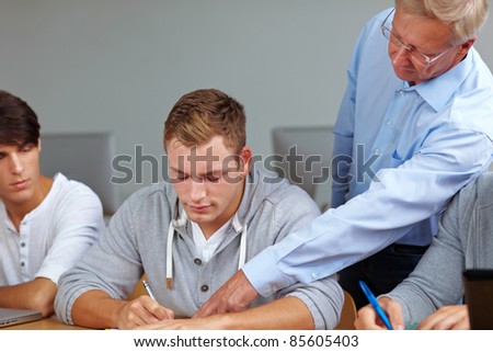Teacher giving student hints in class at test