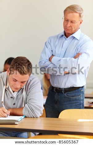 Teacher checking students at test in university