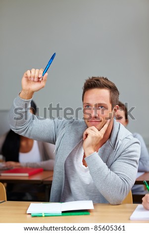 Student raising his hand in class in university