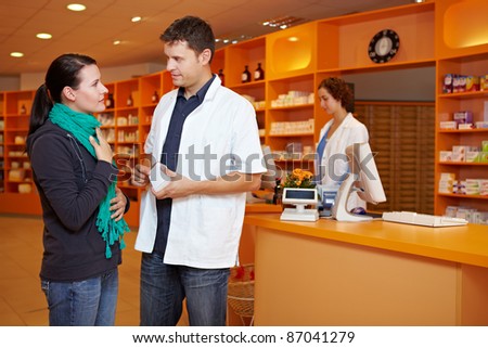 Female customer with cold gets advice from pharmacist in pharmacy