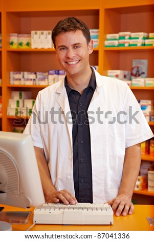 Smiling pharmacist behind the counter of a pharmacy