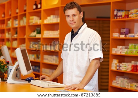 Confident pharmacist standing behind counter in a pharmacy