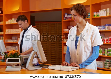 Pharmacist and PTA in pharmacy working behind desk