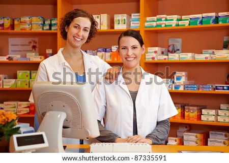 Happy pharmacist and a pharmacy technician in a drugstore