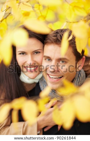 Happy smiling couple in a fall forest with yellow leaves