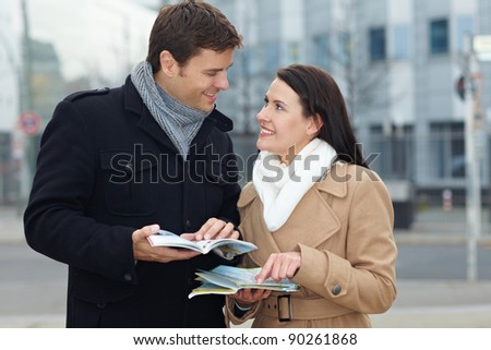 Happy tourists on holiday with tour guide and city map