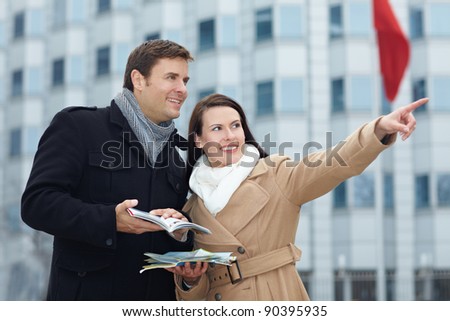 Happy tourists on sightseeing trip with tour guide and city map