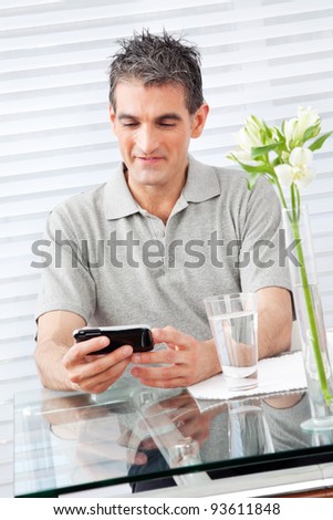 Elderly man looking at his smartphone in restaurant