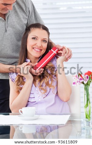 Man giving happy smiling woman a red birthday gift