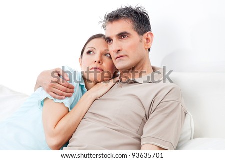 Pensive senior couple thinking on couch at home
