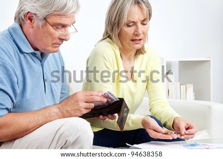 Senior couple with wallet counting Euro money on table at home