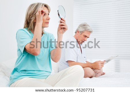 Elderly married couple is busy in bedroom before going to bed