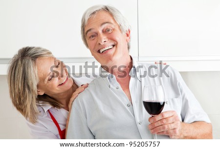 Happy senior couple with glass of red wine