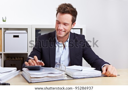Man from internal revenue doing tax audit with calculator in office