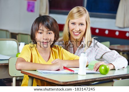 Teacher coaching Japanese student in elementary school