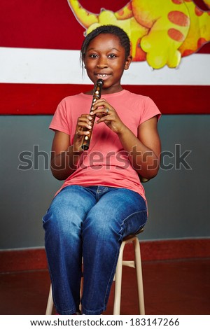African girl learning to play music instrument in elementary school