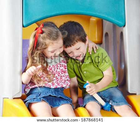 Boy and girl as children friends playing together in a kindergarten