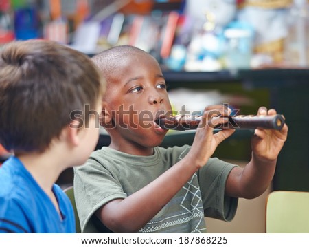 African child playing flute in a music school