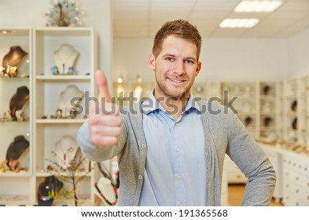 Smiling man in jewelry store holding his thumbs up