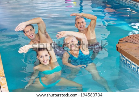 Happy group doing aqua fitness class in a swimming pool