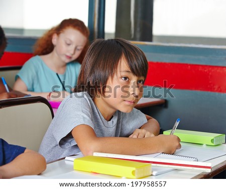 Some students writing a pop quiz in elementary school class