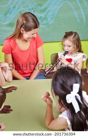 Girl playing flute in a musical school near the music teacher