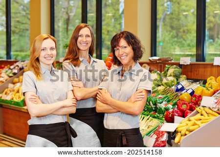 Group of three happy sales women in a supermarket