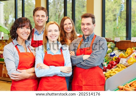 Happy staff team with men and women in a supermarket