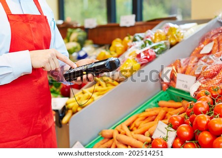Hand of salesperson using mobile data acquisition terminal in a supermarket