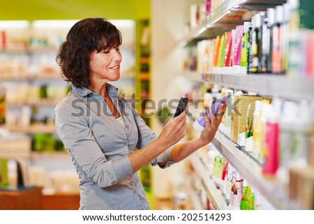 Elderly woman scanning barcode of cosmetics product in a drugstore