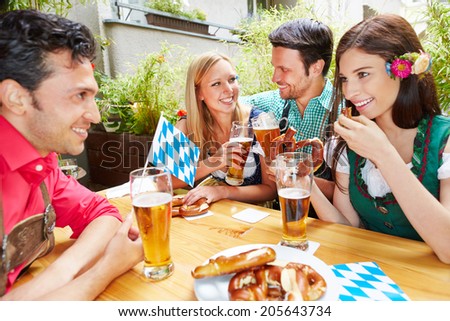 Happy friends talking and flirting in beer garden in summer