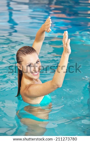 Woman doing back training in water in aqua fitness class