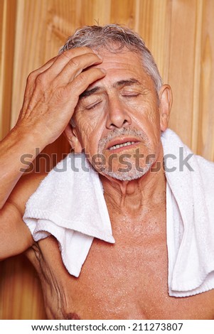 Senior man sweating with towl in hotel sauna in his holidays