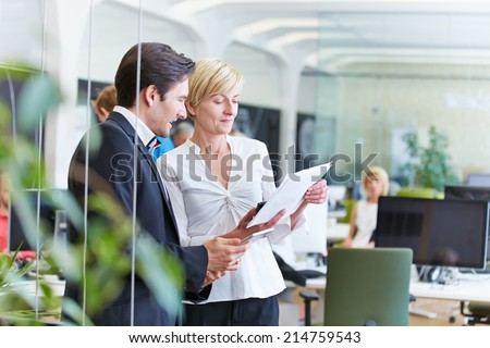 Two business people talking about a contract in office