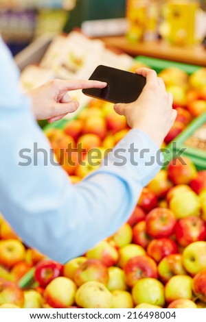 Hand scanning information of fresh fruit with a smartphone in a supermarket