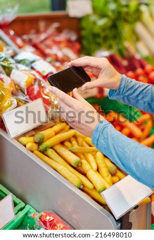 App in smartphone scanning barcode for price comparison in supermarket