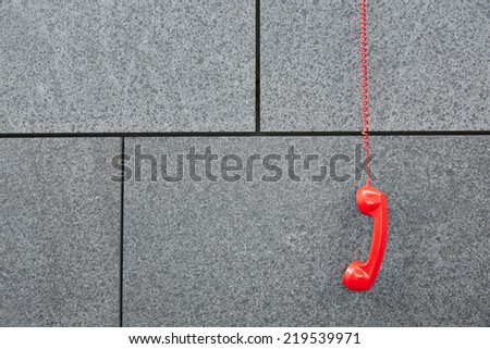 Red emercency call phone hanging down on a wall