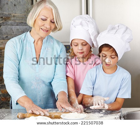 Two children cooking together with grandmother for christmas in a kitchen