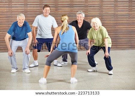 Senior people dancing to music in gym with dance instructor