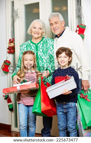 Grandparents with two grandchildren and gifts at christmas eve