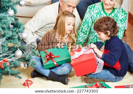 Children celebrating christmas eve with grandparents at home with gifts