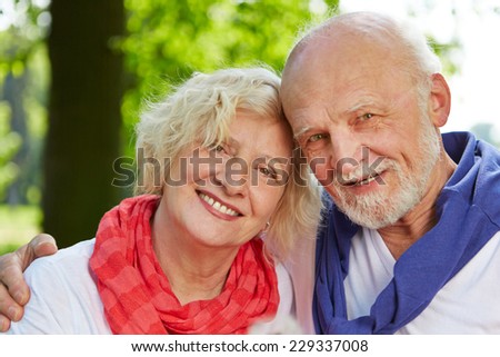 Old man and woman as senior couple in nature in fall