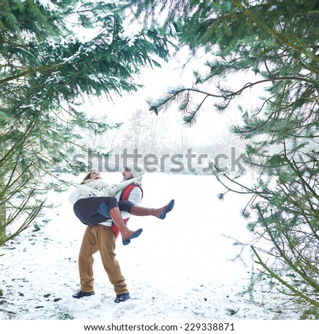 Couple having fun in the snow in a winter forest